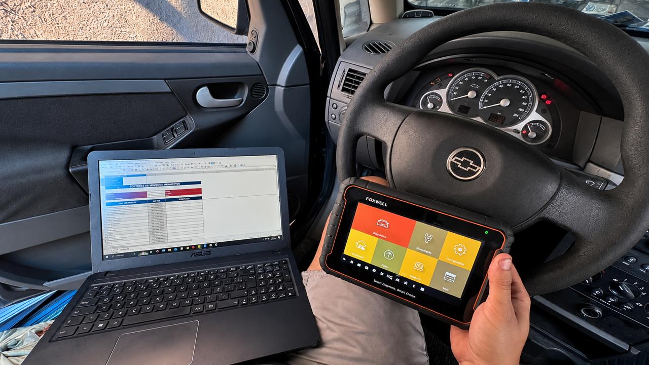 Diagnóstico eletrônico com scanner automotivo e notebook dentro do veículo